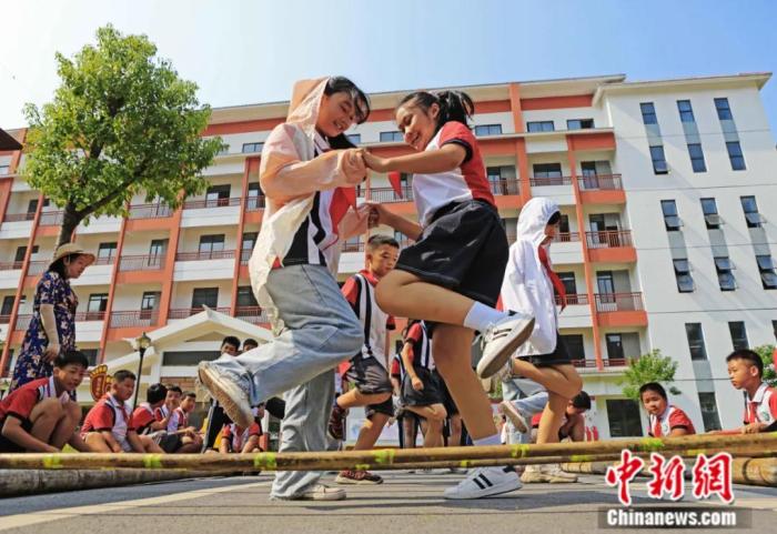 2021年9月,广西柳州市融水苗族自治县苗家小镇小学,学生在跳竹竿。近年来,该校大力开展以民族体育为主的大课间活动。<a target='_blank' href='/'>中新社</a>发 龙涛 摄